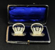 A pair of Geo V silver place name settings depicting Naval crowns with a hexangular base, stamped '