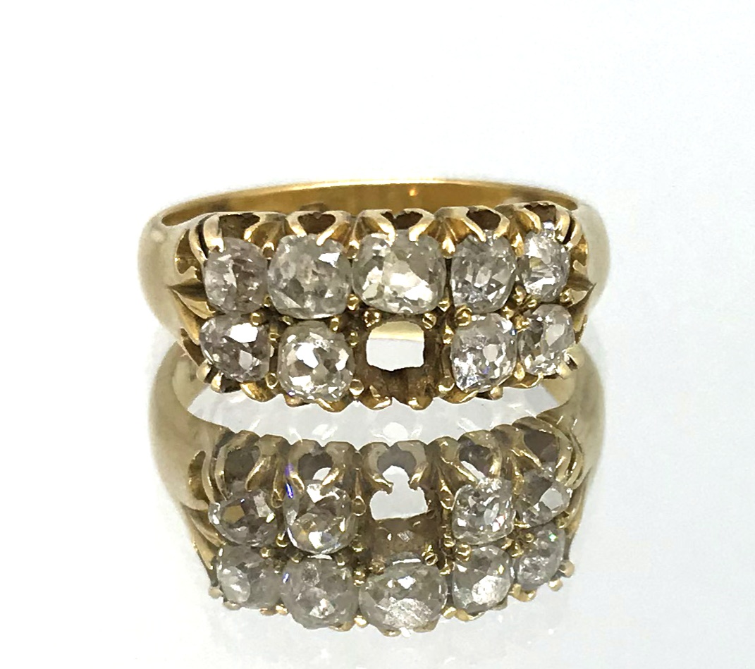 An 18ct diamond nine stone diamond ring (one stone missing), ring size K, approx 5.9gms.