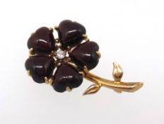A dark ruby style and diamond set brooch, of flower design set in yellow metal, length approx