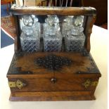A 19th Century walnut three bottle Tantalus, the cabinet with Bramah lock, fitted with a drawer