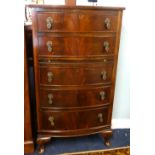 A reproduction bow fronted chest fitted with five drawers and a brushing slide together with a