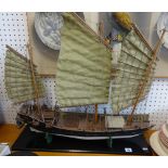 A model of a Chinese junk on a wood base, width 70cm.