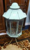 An antique copper lantern originally fitted for gas on a wrought iron stand, height 85cm.