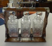 Victorian oak and metal bound three bottle Tantalus (lacks key).