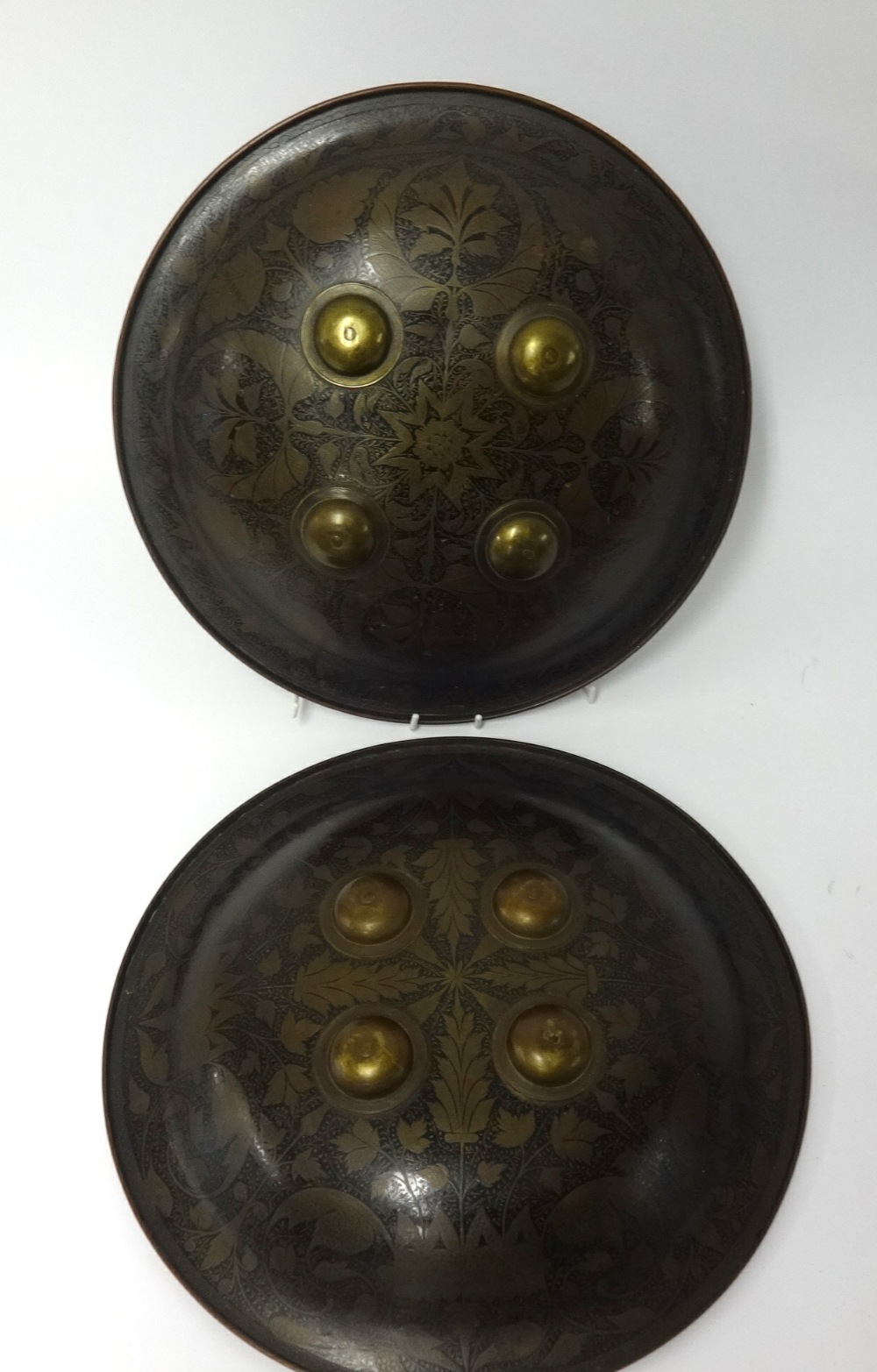 A pair of 19th/early 20th Century Indo-Persian shields, each fitted with arm supports and