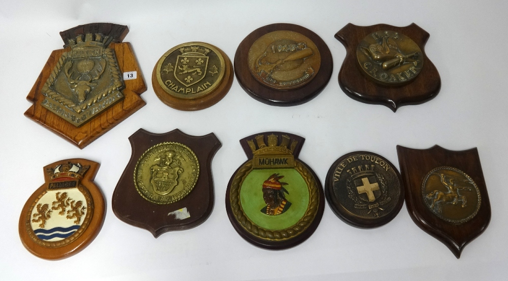 A collection of ships plaques mounted on wood shields, including USS Croaker and Raleigh (10).