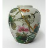 An oriental porcelain jar decorated with bright flowers and a bird, height 14cm.