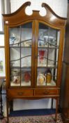 Edwardian mahogany two door display cabinet, with swan neck pediment, fitted with two drawers on