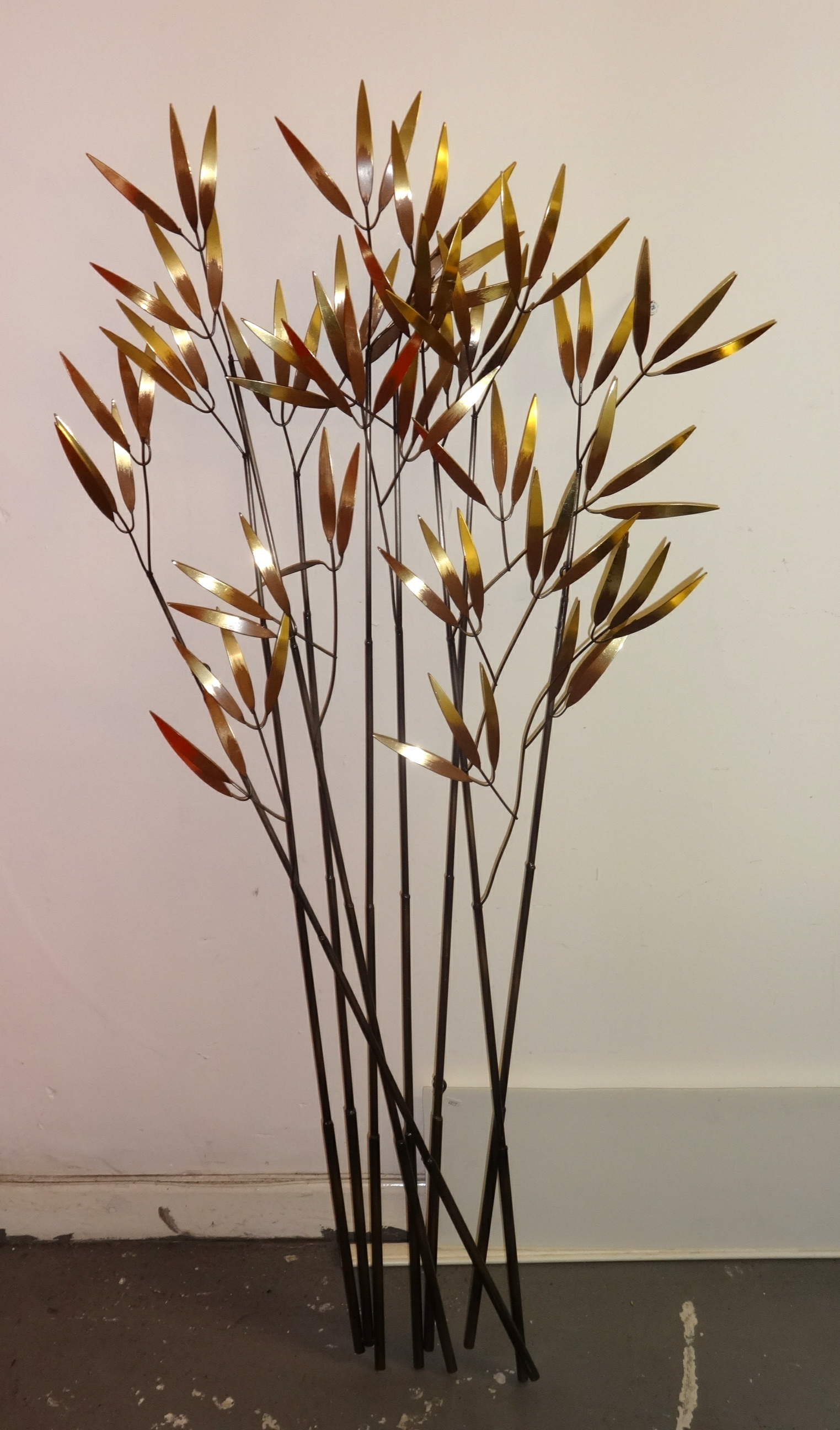 A modern metal art wall sculpture, stylised flowers.