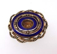 A large Victorian gilt and blue enamel brooch set with a citrine style stone the reverse with a