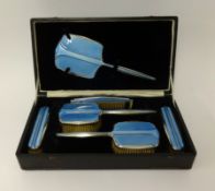 An art deco six pieced cased blue enamel and silver dressing table set, comprising mirror, two