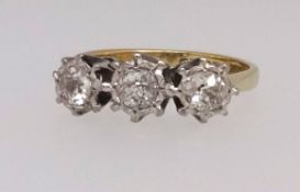 An 18ct yellow and white gold set three stone diamond ring of illusion design, finger size L.