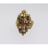 An 18ct gold emerald and diamond ring comprising four round cut emeralds in a rub over set and six
