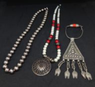 A pearl coral and silver necklace and a Middle Eastern Oman silver pendant and beads.