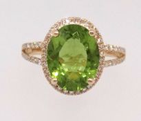 A 14k yellow gold and diamond ring set with an oval cut peridot approx 3.81ct, diamonds approx 0.