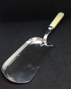 A silver bladed crumb scoop with bone handle.