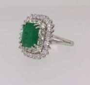 An emerald and diamond rectangular cluster ring, comprising central octagon cut emerald surrounded