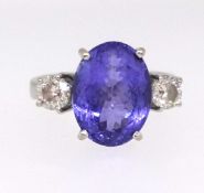 A tanzanite and diamond three stone ring, the centre stone approx 4.730ct, the two diamonds