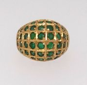 A domed six row emerald dress ring mounted in all yellow gold lattice work design with plain
