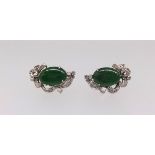 A pair of Nephrite jade and diamond earrings, central oval cut jade, claw set, mounted in all