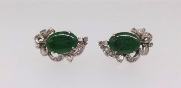 A pair of Nephrite jade and diamond earrings, central oval cut jade, claw set, mounted in all