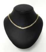 An impressive diamond line necklace, set in 14k yellow gold with 131 round cut diamonds