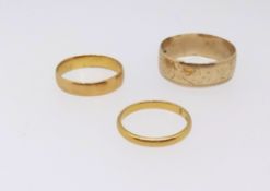 Three gold wedding bands comprising two 22ct bands (5gms) a 9ct band (3.3gms).