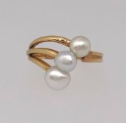 Three stone freshwater pearl dress ring, set in all 18k yellow gold split across 3 bars to one side,