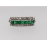 A three row emerald and diamond ring, comprising central row of seven square cut emeralds, outer