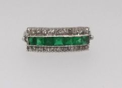 A three row emerald and diamond ring, comprising central row of seven square cut emeralds, outer