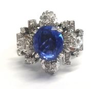 A fine sapphire ring set in white gold, unmarked, of a flower design set with diamonds (the stone