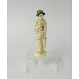 A carved ivory Japanese figure with parasol and book, height 15cm.
