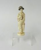 A carved ivory Japanese figure with parasol and book, height 15cm.