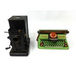 An old tin magic lantern together with a Mettoy typewriter, boxed.