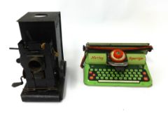 An old tin magic lantern together with a Mettoy typewriter, boxed.