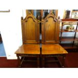 A set of six heavy oak dining chairs of gothic design.