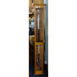 A stick barometer in oak case by Philip & Harris.