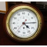 A brass ships clock, on wood mount, running, with key, diameter approx 23cm.