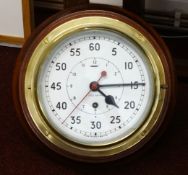 A brass ships clock, on wood mount, running, with key, diameter approx 23cm.