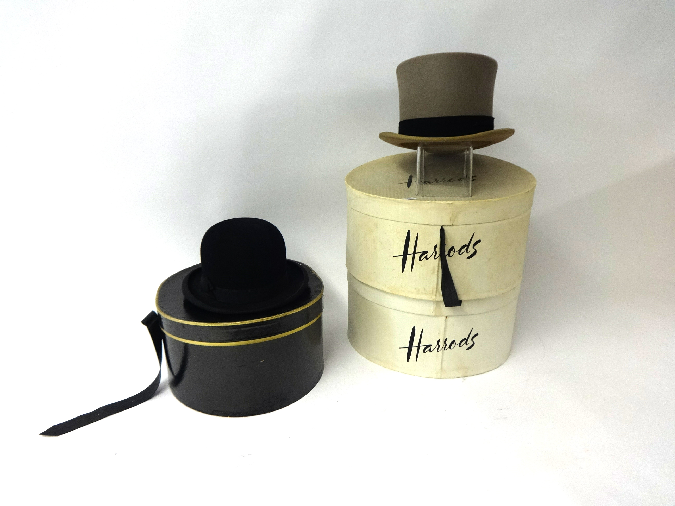 Two old bowler hats, Harrods boxes and another hat.