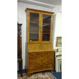 An antique English walnut bureau bookcase the upper section with two glazed doors, enclosing two