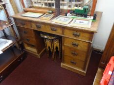 An oak pedestal desk fitted with nine drawers, width 123cm.