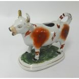 A 19th Century Staffordshire cow creamer, porcelain monkey and Staffordshire white poodle etc (5).