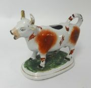 A 19th Century Staffordshire cow creamer, porcelain monkey and Staffordshire white poodle etc (5).