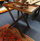 A Butlers tray on folding stand.