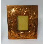 A Newlyn copper picture frame embossed with fish and a shell, impressed 'Newlyn' to verso, 30cm x