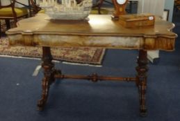 A Victorian walnut centre table with a carved stretcher base, approx 134cm x 70cm.