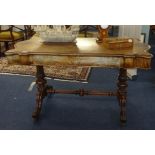 A Victorian walnut centre table with a carved stretcher base, approx 134cm x 70cm.