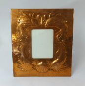 A Newlyn copper picture frame embossed with fish and a shell, impressed 'Newlyn' to verso, 30cm x