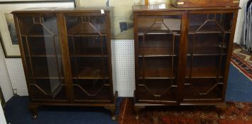 A pair of mahogany bookcases with astragal glazing bars on short cabriole legs.